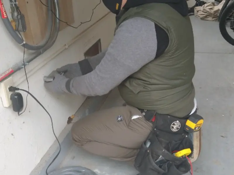 Electrician performing outlet wiring in a Northdale garage